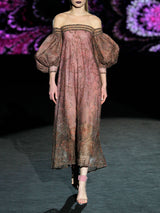 Vestido largo evasé con escote palabra realizado en tul tatoo bordado con diminutos cristales y cuenta con brillantes bordados de inspiración floral, maxi mangas y escote palabra de Hannibal Laguna