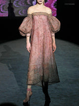 Vestido largo evasé con escote palabra realizado en tul tatoo bordado con diminutos cristales y cuenta con brillantes bordados de inspiración floral, maxi mangas y escote palabra de Hannibal Laguna