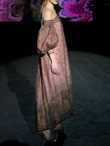 Vestido largo evasé con escote palabra realizado en tul tatoo bordado con diminutos cristales y cuenta con brillantes bordados de inspiración floral, maxi mangas y escote palabra de Hannibal Laguna