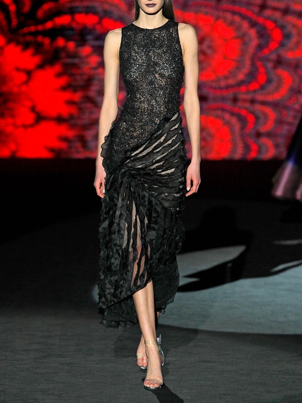 Vestido realizado en malla bordada de corte asimétrico y falda recogida en un lado con volantes de organza negro de Hannibal Laguna