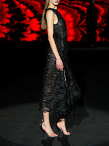 Vestido realizado en malla bordada de corte asimétrico y falda recogida en un lado con volantes de organza negro de Hannibal Laguna