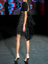Vestido corto de fiesta realizado en organza con micro volantes, maxi mangas cortas y delicado chantilly colocado en forma de U de Hannibal Laguna