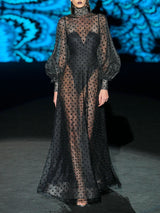 Vestido de vuelo realizado en tul plumeti y chantilly negro, cuello cisne y maxi mangas de Hannibal Laguna