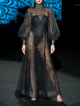 Vestido de vuelo realizado en tul plumeti y chantilly negro, cuello cisne y maxi mangas de Hannibal Laguna