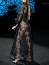 Vestido de vuelo realizado en tul plumeti y chantilly negro, cuello cisne y maxi mangas de Hannibal Laguna