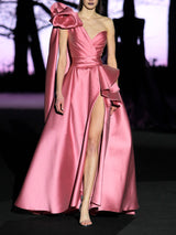 Vestido de fiesta realizado en mikado color rosa loto, cuerpo corazón con cruce de drapeados, flor xl en hombro derecho y falda de vuelo cruzada con abertura de Hannibal Laguna