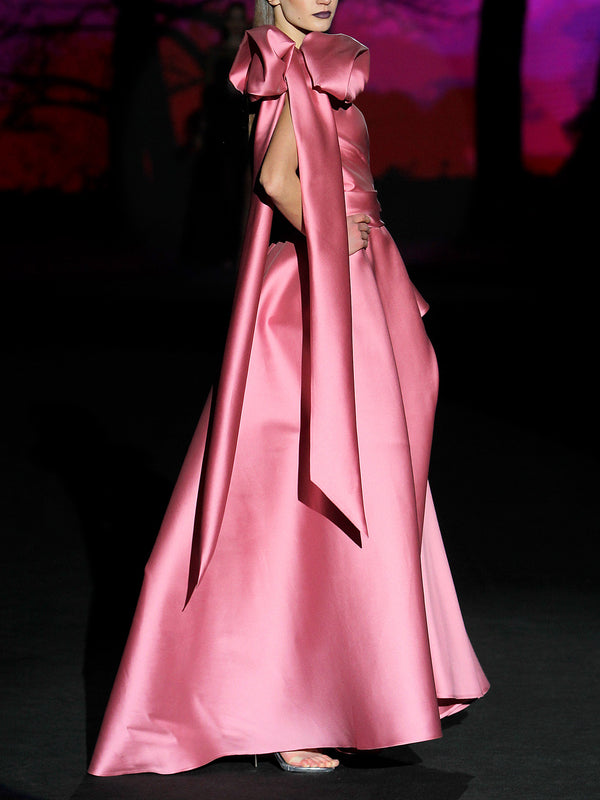 Vestido de fiesta realizado en mikado color rosa loto, cuerpo corazón con cruce de drapeados, flor xl en hombro derecho y falda de vuelo cruzada con abertura de Hannibal Laguna
