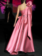 Vestido de fiesta realizado en mikado color rosa loto, cuerpo corazón con cruce de drapeados, flor xl en hombro derecho y falda de vuelo cruzada con abertura de Hannibal Laguna