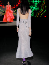 Vestido de fiestaen lentejuelas plata mate, cuerpo escote V con mangas largas y falda sirena entallada. Lazo a modo de cinturón de HANNIBAL LAGUNA.