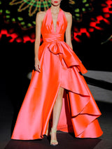 Vestido de fiesta en mikado color salmón, escote pico tipo halter y falda de capa con abertura cruzada y capote de adorno de HANNIBAL LAGUNA.