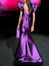 Vestido de fiesta realizado en mikado morado con escote corazón cruzado drapeado, maxi mangas y falda de vuelo cruzada con pliegues de Hannibal Laguna