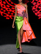 Vestido de fiesta midi en mikado color salmón y martelé color verde, cuerpo asimétrico y falda sirena y lazo XL granate rodeando la cintura de HANNIBAL LAGUNA.