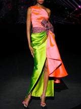 Vestido de fiesta midi en mikado color salmón y martelé color verde, cuerpo asimétrico y falda sirena y lazo XL granate rodeando la cintura de HANNIBAL LAGUNA.