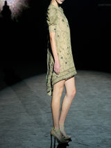 Vestido evasé realizado en gasa verde olivo bordada con diminutos cristales y cuenta con brillantes bordados de inspiración floral y mangas con volumen de Hannibal Laguna