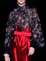 a woman in a red dress holding a red bag