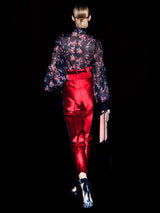 a man in a red dress holding a skateboard