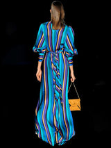 a woman in a blue dress holding a cell phone