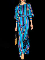 a woman in a blue dress holding a cell phone