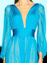 a woman in a blue dress holding a cell phone