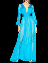 a woman in a blue dress holding a cell phone
