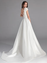 Vestido UBEROI de Hannibal Laguna Couture Novia en mikado pique color natural con cuerpo de chantilly, escote en "V" y fajín con delicado drapeado.