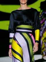 Blusa cortada al bies en satín de seda negro y maxi puños en satín estampado de rayas. Falda evasé cortada al bies en satín de rayas y cinturilla ancha de Hannibal Laguna