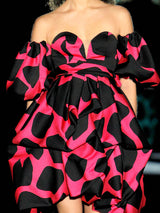 a woman in a red dress is holding a flower