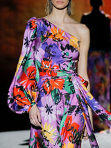 Vestido de noche en satín print maxi flores multicolor con escote asimétrico, manga XL, lazada a modo de fajín y falda evase al bies de Hannibal Laguna