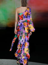 Vestido de noche en satín print maxi flores multicolor con escote asimétrico, manga XL, lazada a modo de fajín y falda evase al bies de Hannibal Laguna