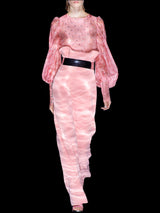 a woman in a pink dress holding a pink object