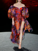 Vestido en organza estampada, amplia falda cruzada con abertura y cuerpo con escote V y mangas XXL de Hannibal Laguna