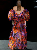 Vestido en organza estampada, amplia falda cruzada con abertura y cuerpo con escote V y mangas XXL de Hannibal Laguna