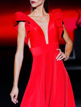 Vestido en neopreno ecológico rojo con falda de nesgas y cuerpo con escote V y mangas XXL de Hannibal Laguna