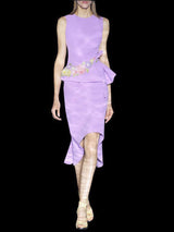a woman in a pink dress holding a purple frisbee