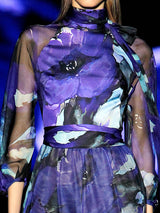 a woman in a purple dress standing next to a purple horse