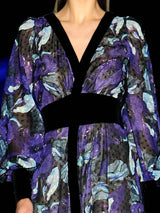 a woman in a purple dress holding a black umbrella