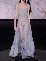 Vestido largo con gran vuelo en organza gris tornasol bordada con cristales y cuerpo de tirantes con flecos en pedreria grisde Hannibal Laguna