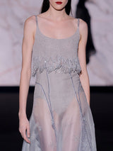 Vestido largo con gran vuelo en organza gris tornasol bordada con cristales y cuerpo de tirantes con flecos en pedreria grisde Hannibal Laguna