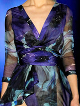 a woman in a purple dress sitting on a bench