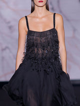 Vestido corto con falda asimétrica de gasa de seda negra con cuerpo bordado formando flecos con lentejuelas ovaladas y escote cuadrado de Hannibal Laguna