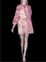 a woman in a pink dress holding a pink umbrella