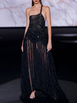 Vestido asimétrico largo con falda sirena en micro volantes de tul negro y cuerpo bordado formando flecos con lentejuelas ovaladas de Hannibal Laguna