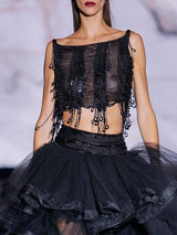 Conjunto compuesto por cuerpo bordado en cristales a modo de flecos con lentejuelas ovaladas y escote barca , falda midi con volantes de tul negro y canesú bordado en cristal de Hannibal Laguna