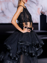 Conjunto compuesto por cuerpo bordado en cristales a modo de flecos con lentejuelas ovaladas y escote barca , falda midi con volantes de tul negro y canesú bordado en cristal de Hannibal Laguna