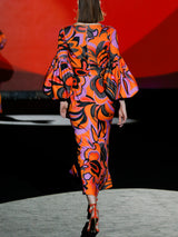 Vestido de fiesta en neopreno estampado psicodélico escote de pico, pechos con pliegues. Fajín al bies y falda sirena midi de Hannibal Laguna