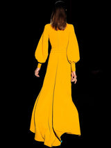 a woman in a yellow dress holding a cell phone