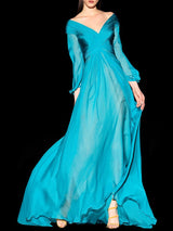 a woman in a blue dress holding a tennis racquet