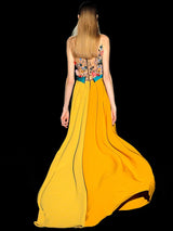 a woman in a yellow dress standing next to a yellow fire hydrant