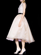 a woman in a white dress is holding a tennis racket