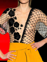 a woman in a dress holding a glass of wine